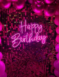 happy birthday neon sign surrounded by pink balloons