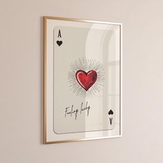 a framed playing card with a red heart on it