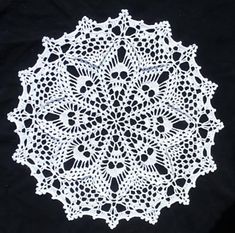 a white doily on a black background