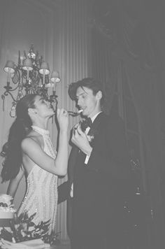 a man and woman feeding each other cake