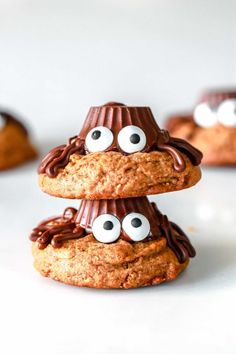 three cookies with googly eyes and chocolate chips on top are stacked in the shape of pyramids