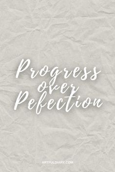 the words progress over perfection written in white ink on crumpled paper with an aged background