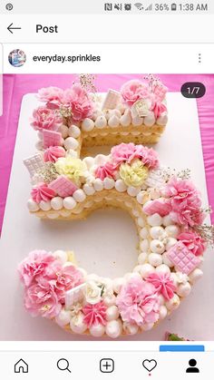 the letter e is made out of cookies and decorated with pink flowers, white icing and beads