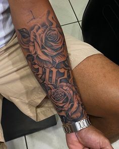 a man with a cross and roses tattoo on his arm