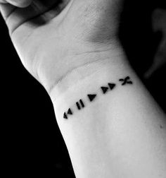 a wrist tattoo with roman numerals is shown on an iphone screen, and it appears to be in black and white