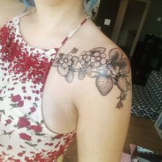 a woman with blue hair has a flower tattoo on her shoulder