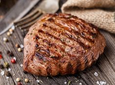 a piece of steak sitting on top of a wooden table