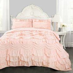 a bed with pink ruffled bedspread and pillows