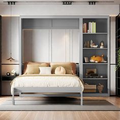 a white bed sitting next to a book shelf filled with books on top of a hard wood floor