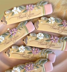 four decorated cookies on a plate with thank you written on the top and flowers in the middle