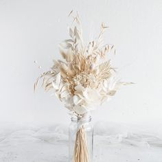 a vase filled with dried flowers on top of a table