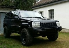 a black suv parked in front of a house