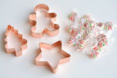 three cookie cutters and some candy canes on a table