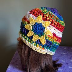 a woman's head wearing a multicolored crocheted beanie hat