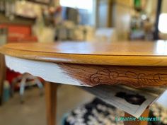 a close up of a wooden table with writing on the top and bottom part of it