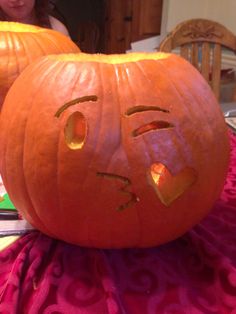 two carved pumpkins sitting on top of a table