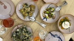 a table topped with lots of plates and bowls filled with different types of food on top of it