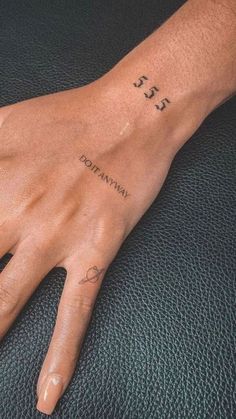 a person's hand with a small tattoo on it