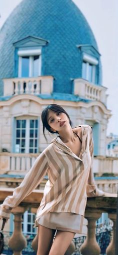 a woman posing in front of a building