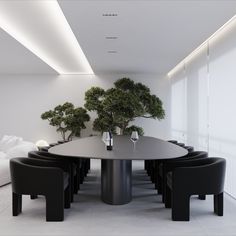 a dining room table with black chairs and a bonsai tree in the center, surrounded by white couches