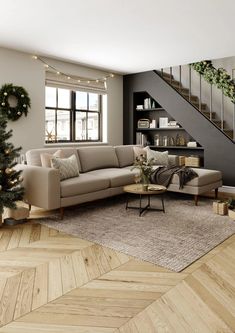 a living room filled with furniture and a christmas tree in front of a staircase case