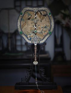 an elaborately decorated clock sitting on top of a wooden table