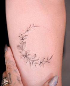 a woman's arm with a flower tattoo on the left side of her body