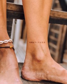 a woman's feet with a tattoo on the ankle that reads, beautiful written in cursive writing