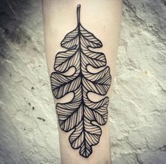 a black and white leaf tattoo on the leg