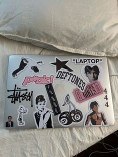 a laptop with stickers on it sitting on a bed