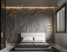 a modern bedroom with stone walls and flooring, along with a large bed in the middle