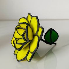 a yellow flower sitting on top of a white table