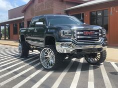 a large black truck parked in front of a building