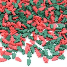 red and green confetti sprinkles are scattered on a white surface