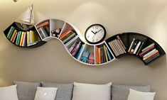 a living room with a couch, bookshelf and clock mounted to the wall