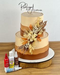 a three tiered cake sitting on top of a wooden table next to paint bottles