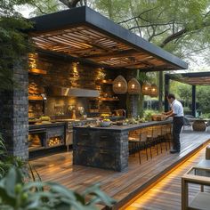 a man standing in front of an outdoor kitchen on a wooden deck surrounded by greenery