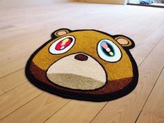 a brown bear rug with eyes and nose on the floor in front of a window