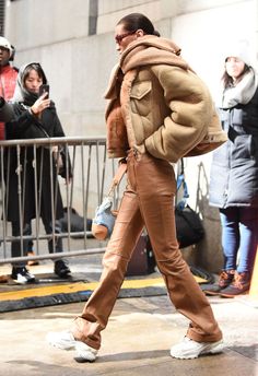 a woman walking down the street in brown pants