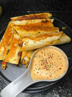 a plate topped with quesadillas and dipping sauce