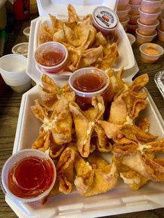 some food is sitting on a tray with sauces and condiments next to it