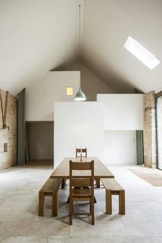 an empty room with a long table and benches