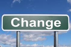 a green street sign that says change on the side of it with clouds in the background