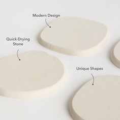 three white wooden discs with different shapes and sizes labeled in the following words, on a white surface