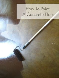 a close up of a paint brush on top of a wooden table with the words how to paint a concrete floor