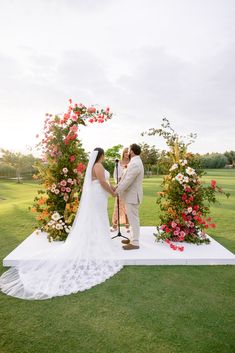 a bride and groom standing at the alter during their wedding ceremony in an open field