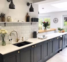 a kitchen with black cabinets and white counter tops