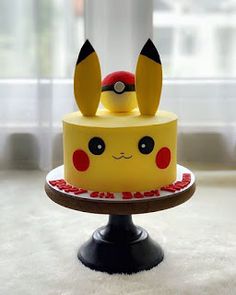 a pokemon cake with pikachu ears on top is sitting in front of a window