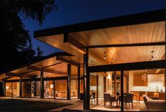 a large open living room and dining area at night