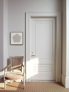 an empty chair in front of a white door